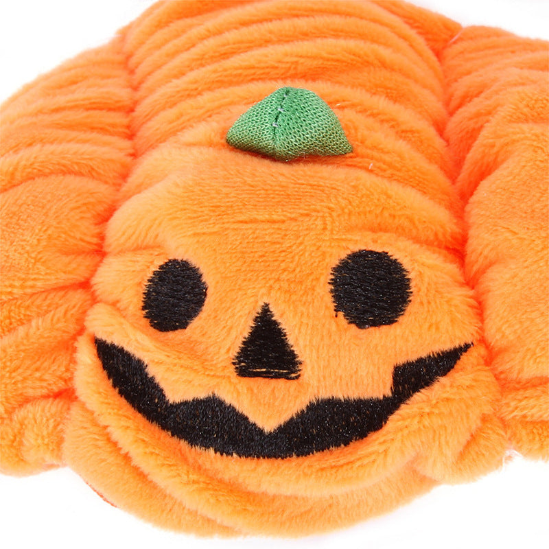 Close-up of the pumpkin hat's stitched jack-o'-lantern face and plush texture
