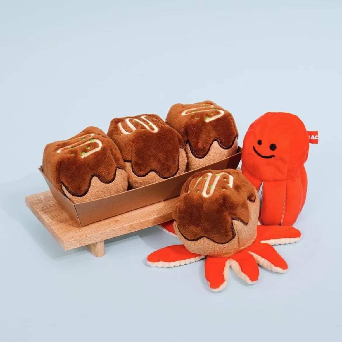 Mugi's takoyaki plush snuffle toy: plush takoyaki in a wooden tray with a red octopus and red tentacle legs