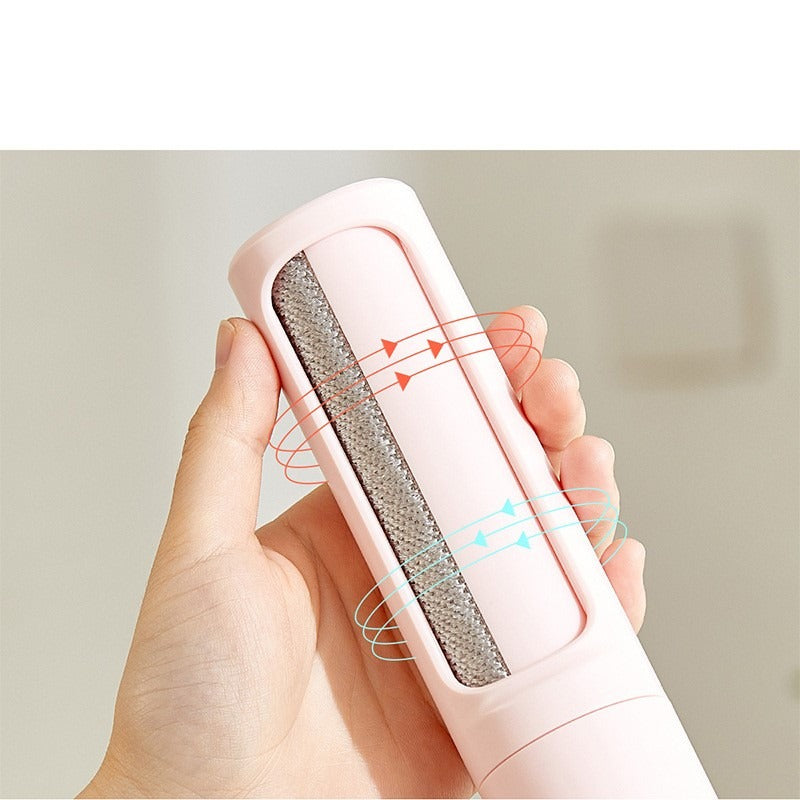 Pet hair remover in hand showing the fur-catching brush strip (pink shown for detail)