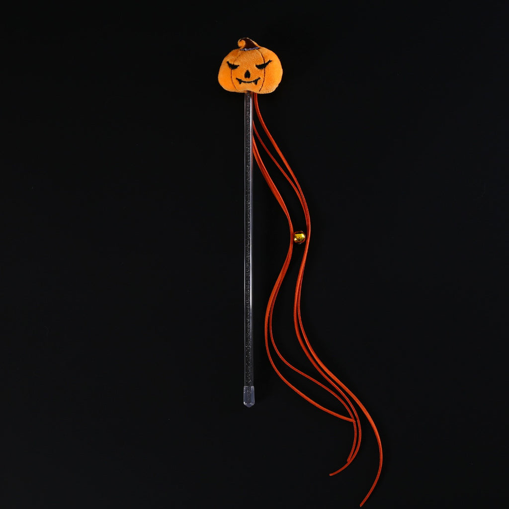 Pumpkin teaser wand with orange tassels and a bell