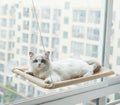 Makuro's Window Watchtower: white cat lounging on a khaki suction-cup window hammock